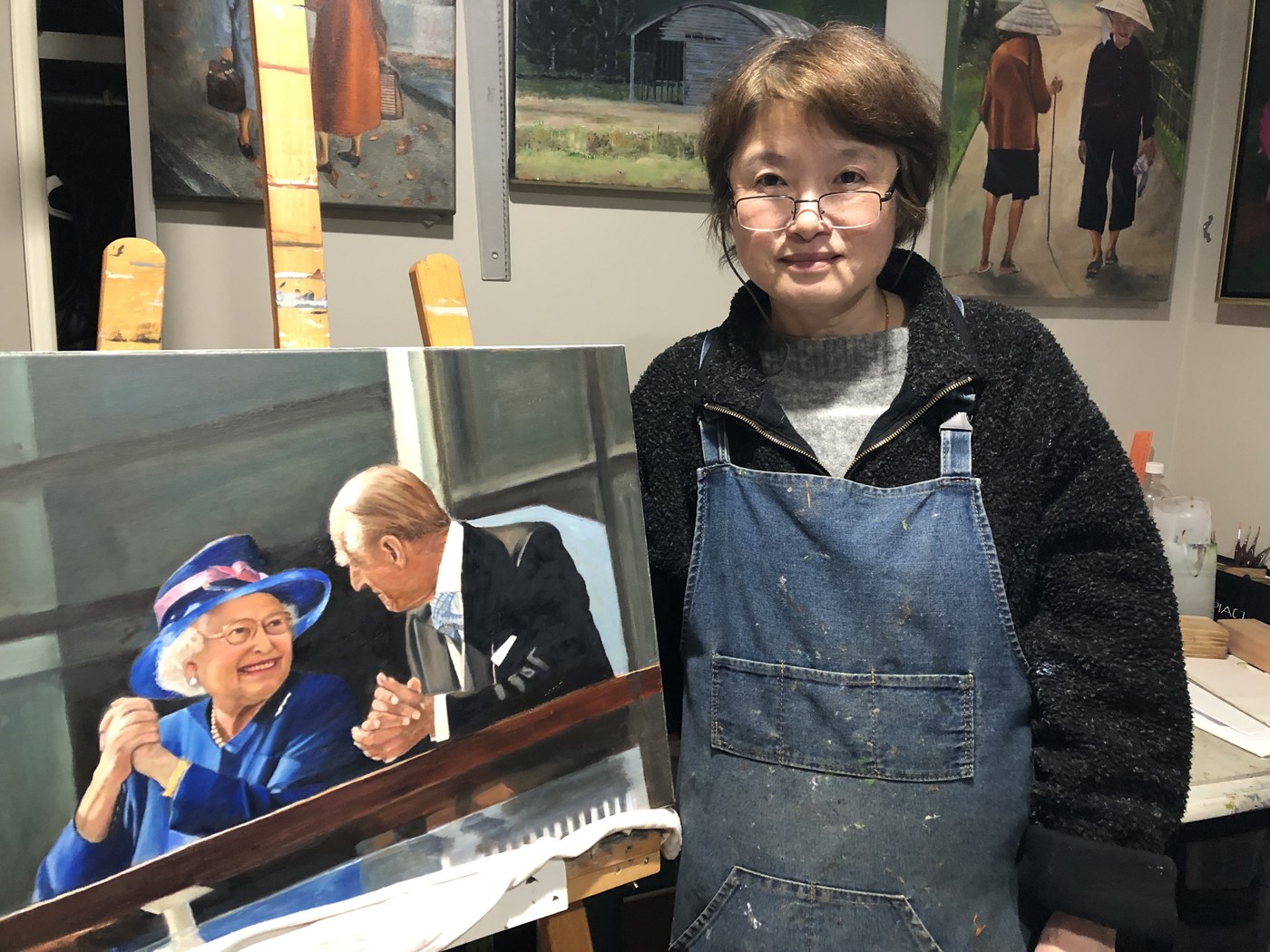 Ping Burtt in her Christchurch studio, beside her painting of the Queen and Prince Philip